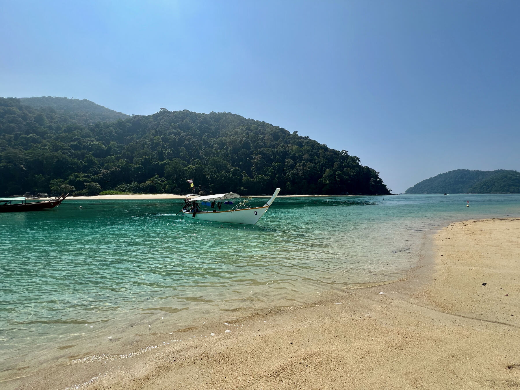 Longtail boat in clear water off a Surin beach
